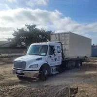 Truck with a beige container parked on a construction site