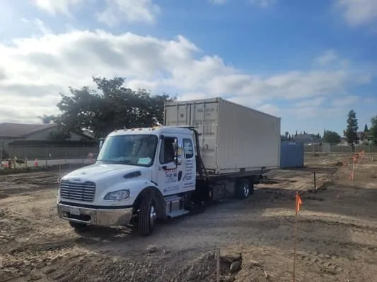 Truck with a beige container at a construction site