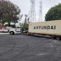 Truck transporting a Hyundai container in a parking lot