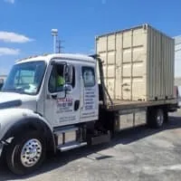 Truck with a beige container in a parking lot