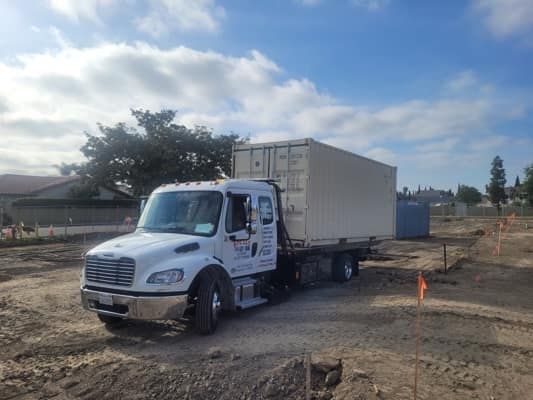 Truck with a beige container at a construction site