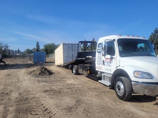 Truck with a white container on a dirt road